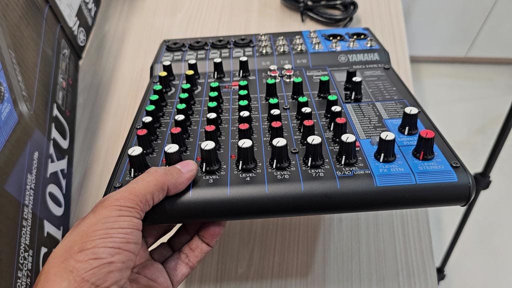 Yamaha MG10XU held in one hand to show its compact size